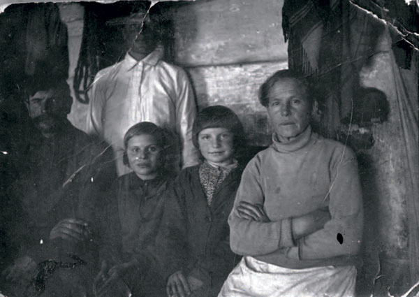 С мамой Ефросиньей, папой Панфилом (слева). Маленькая Женя со стрижкой "под горшок"