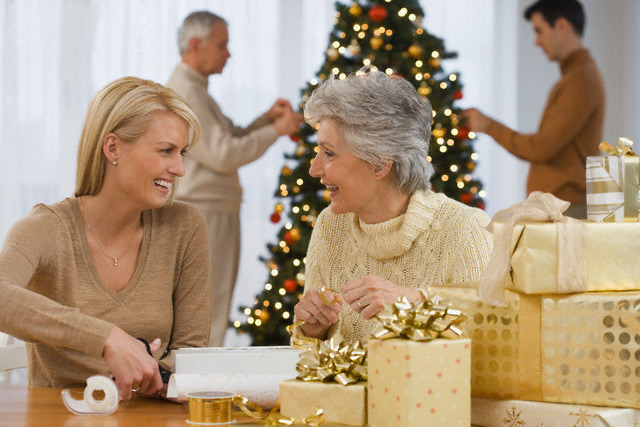 Mother and adult daughter wrapping Christmas gifts