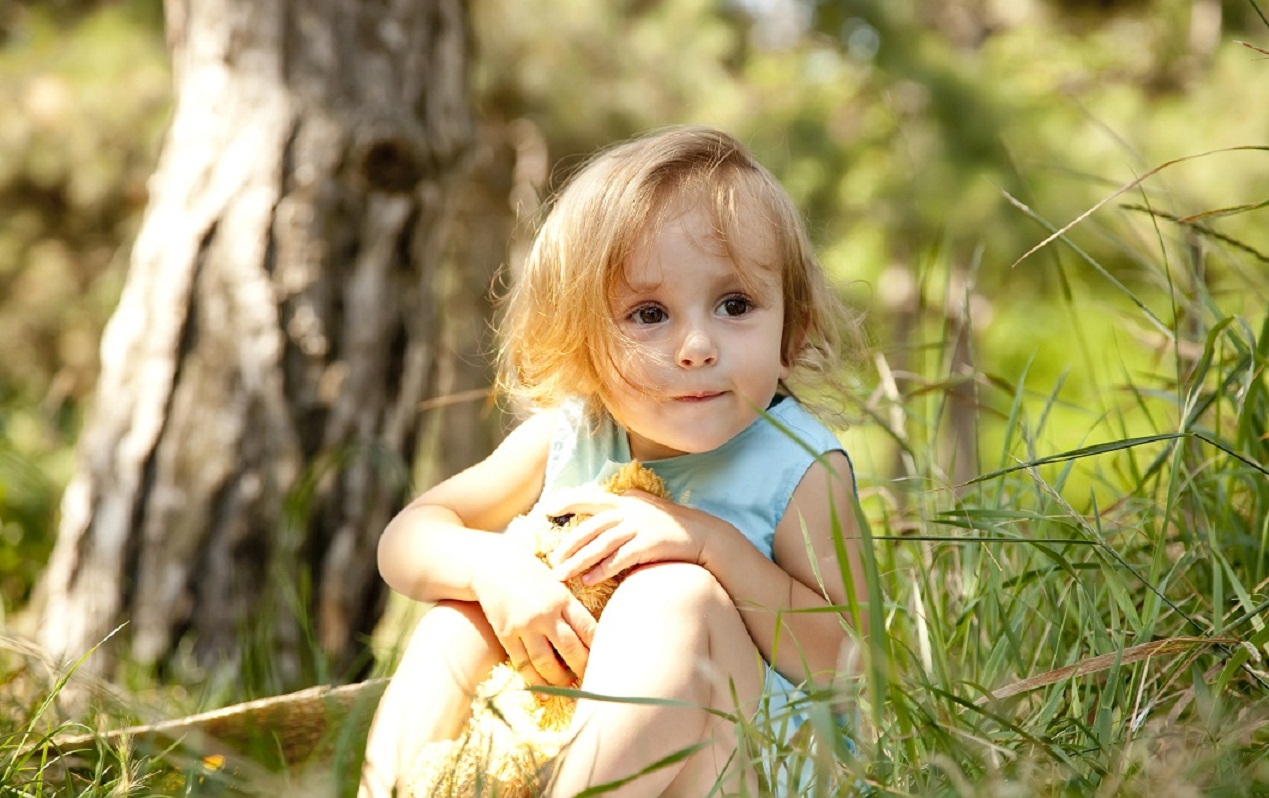 cute little girl hiding in a park