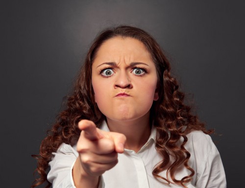 angry young woman pointing at camera