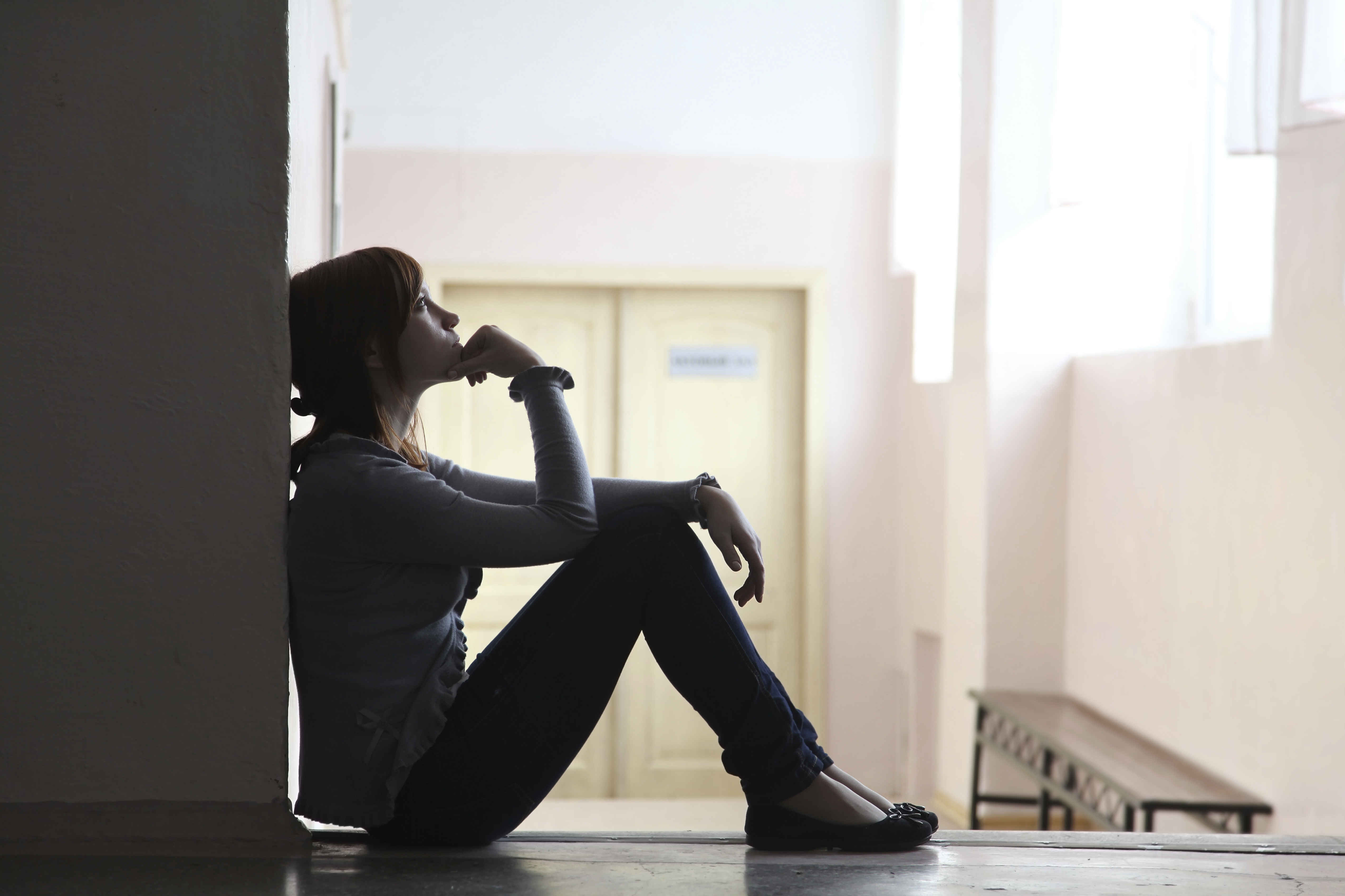 silhouette of a girl student sitting on the floor and thinking