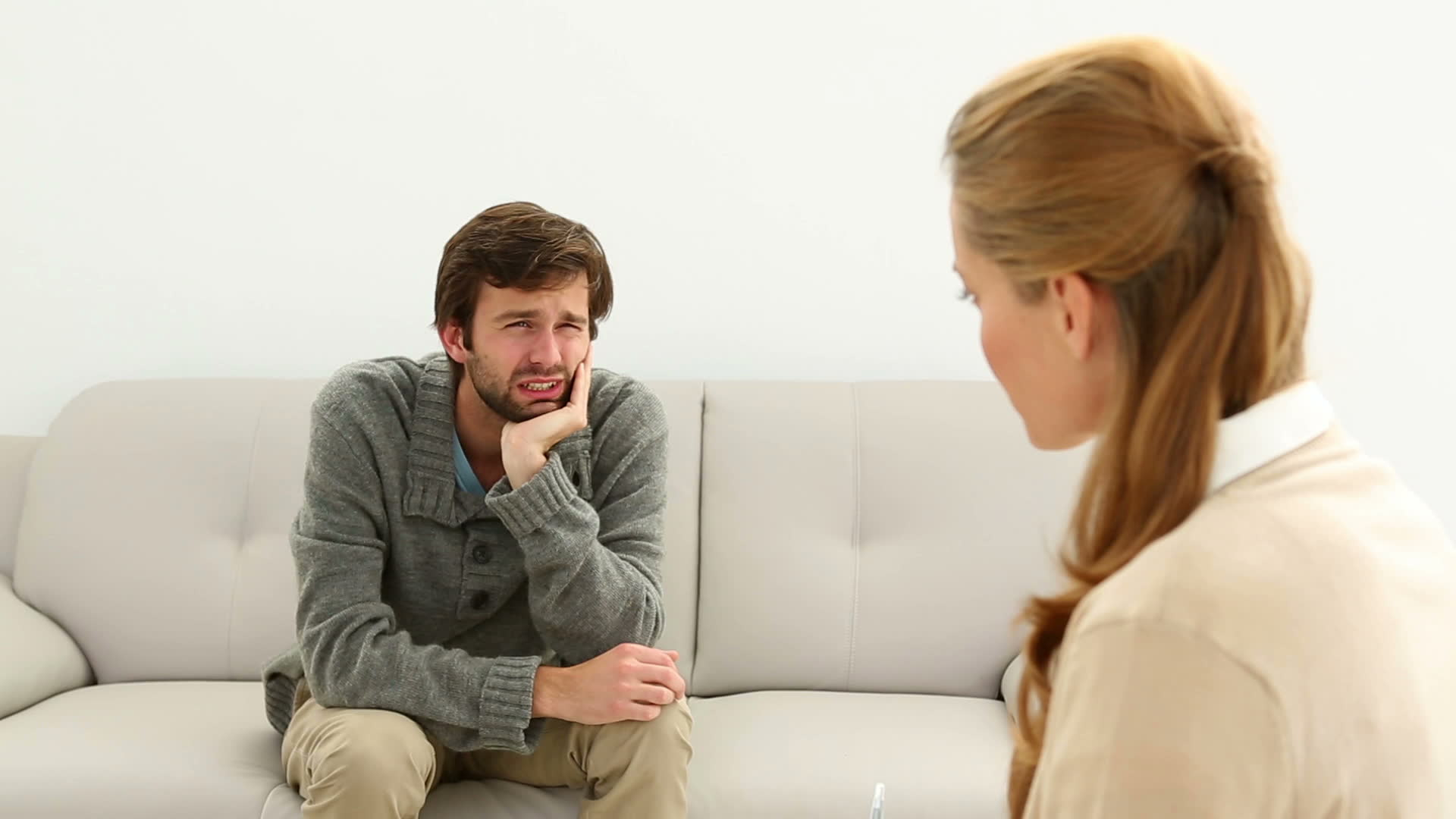 stock-footage-young-man-sitting-on-sofa-talking-to-his-therapist-at-therapy-session