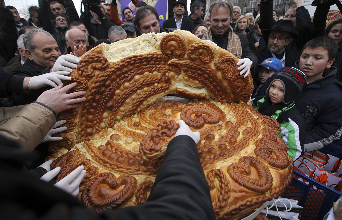 People gather to receive a piece of traditional Christmas bread, marking the Orthodox Christmas Day festivities, at Terazije Square in Belgrade January 7, 2011. Serbian Orthodox believers celebrate Christmas on January 7, according to the Julian calendar. REUTERS/Marko Djurica (SERBIA - Tags: SOCIETY IMAGES OF THE DAY RELIGION) ORG XMIT: MDJ01