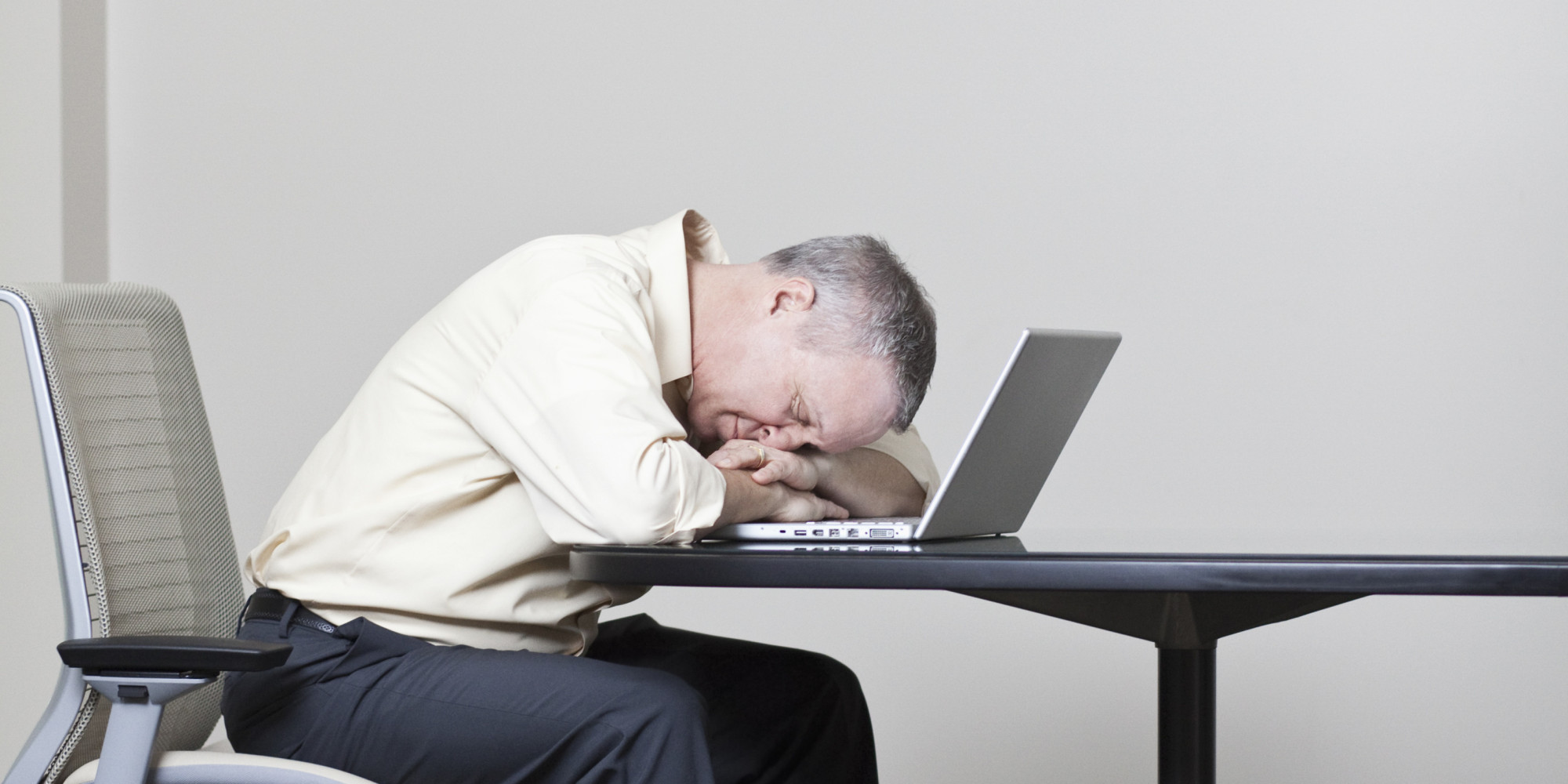 Caucasian businessman sleeping on laptop