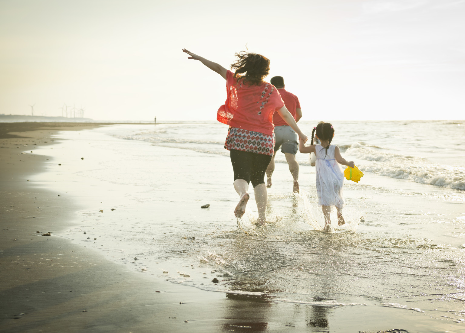 Family running on the beach happily