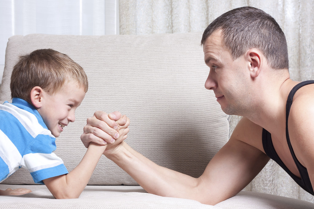 Father and young son are fighting, indoor