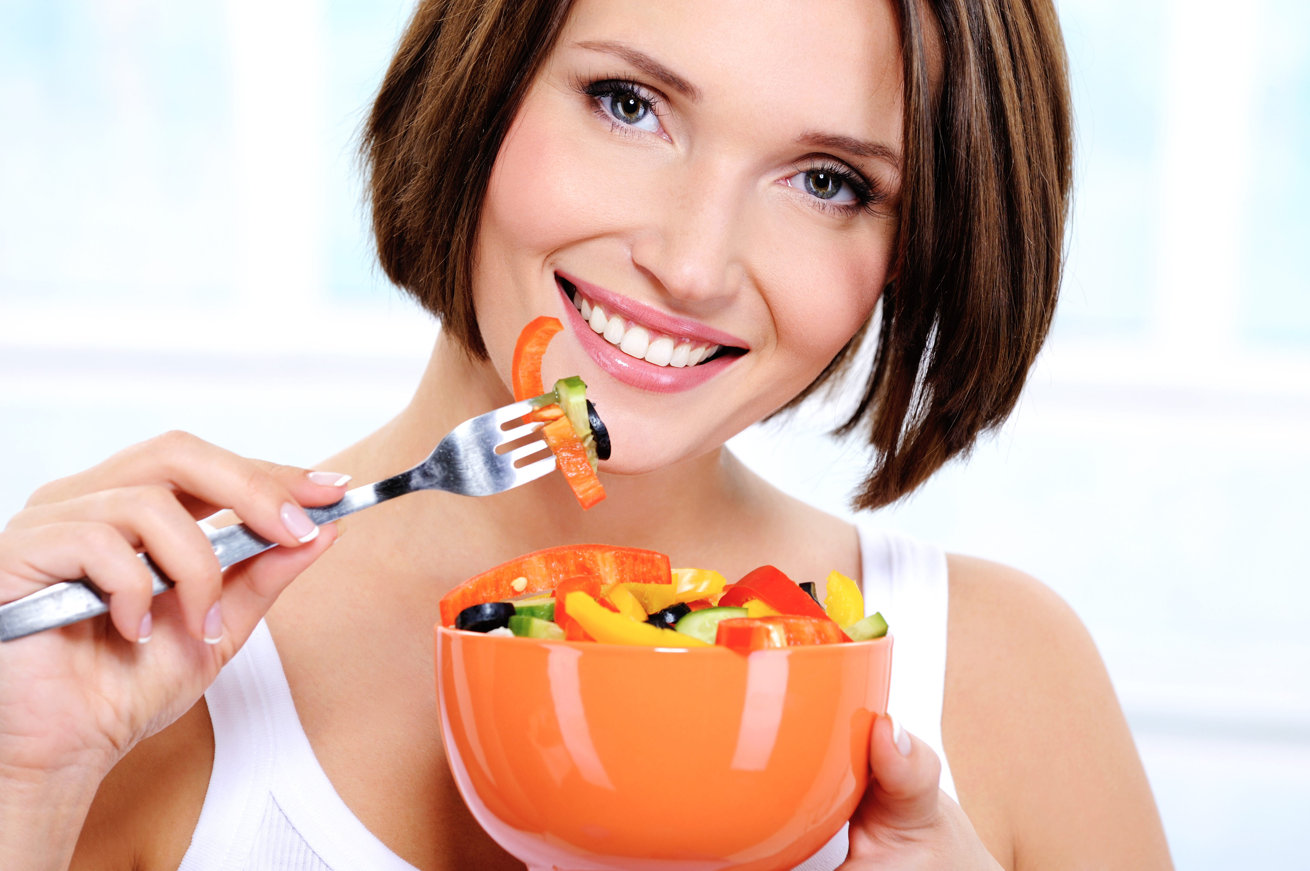 woman with a plate of  vegetable salad in hands